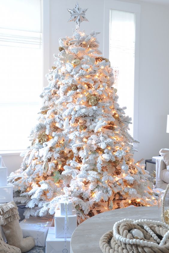 flock Christmas tree with lights and gilded pinecones