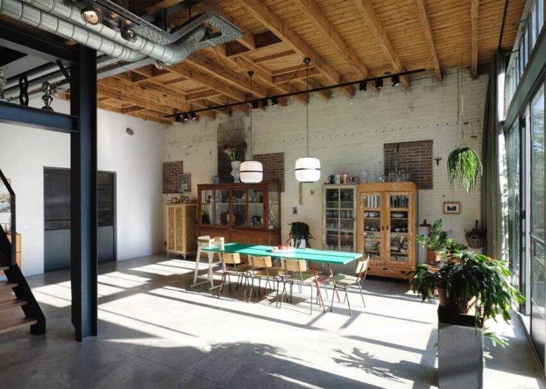 Vintage and mid-century modern glass cabinets look whimsy in an industrial space, and a window wall brings much light in