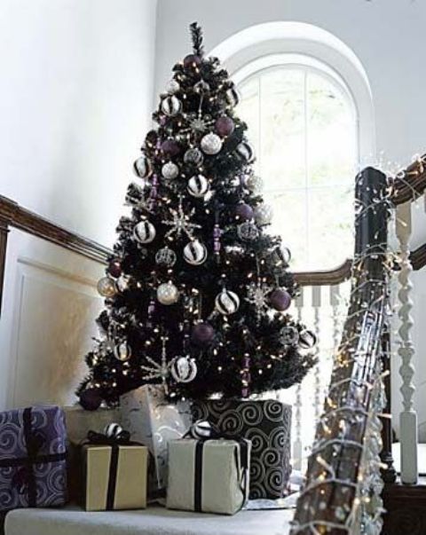 a black tree with white and purple decor looks non-traditional and fresh