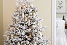 12 gold and silver ornaments look neutral and chic on a flocked tree