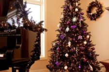 13 a wreath and  tree in black is chic and purple adds just the pop of color to this living room