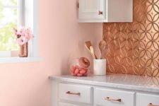 14 a tin-tile backsplash, matching copper cabinet pulls, and serene pink walls make for a charming kitchen corner