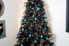 16 a black tree decorated with lights and turquoise baubles for a contrast