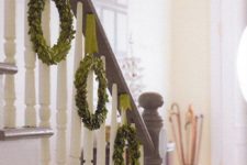 20 green wreaths hanging from the banister