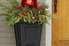 21 simple urn filled with evergreens, berries and ornaments