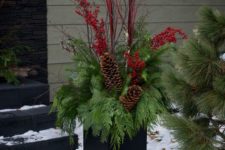 22 a modern black urn, foliage, pinecones, berries and red branches