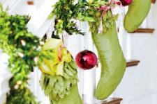 22 greenery garland wrapping around the banister and green stockings