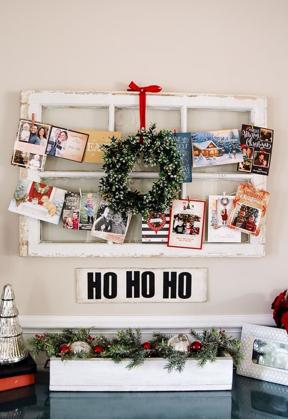 old window frame wwith a mini wreath and cards and pics hanging