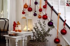 24 large colorful ornaments hanging from the staircase