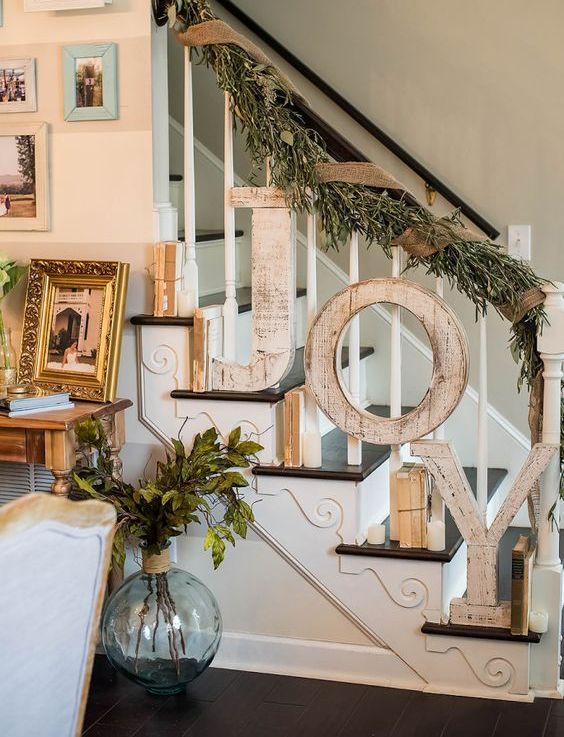 shabby wooden JOY letters attached to the banister and a foliage and burlap garland