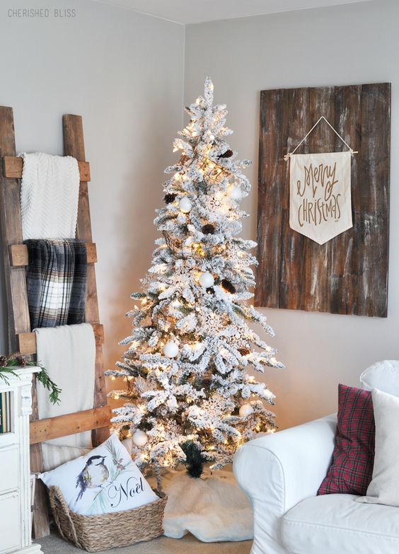 white ornaments and pinecones make the tree look very natural