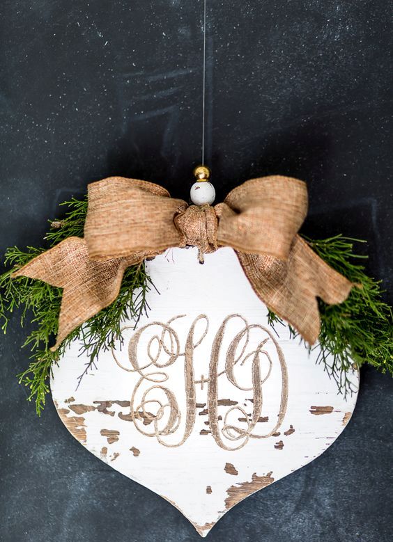 carved monogram into a rustic wood Christmas ornament