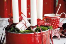 31 red tin filled with white candles, moss and small gift packs
