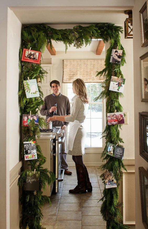 an evergreen garland over the entrance with photos attached