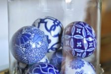 32 blue and white ornaments in a cloche as a Christmas display