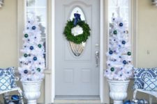 35 navy, blue and white Christmas porch decor with ornaments and white trees in urns