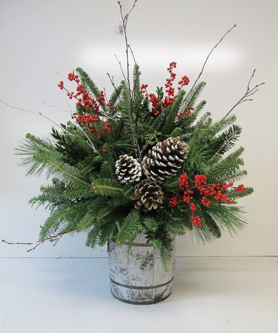 small barrel arrangement with evergreens, pinecones and berries