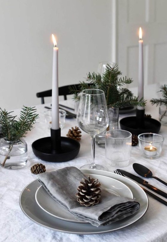 a Nordic Christmas table with neutral linens, white candles, pinecones, evergreens for a cozy Christmas dinner