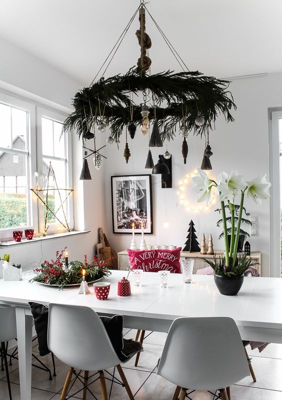 a Scandinavian Christmas chandelier with evergreens, vintage black and silver ornaments is a beautiful idea