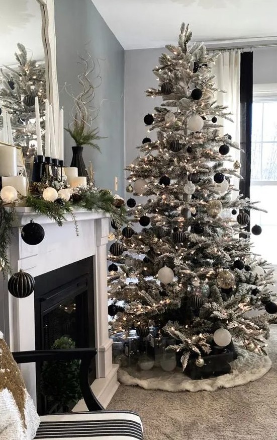 a beautiful flocked Christmas tree with white, clear and black ornaments is a very chic and cool idea for glam Christmas decor