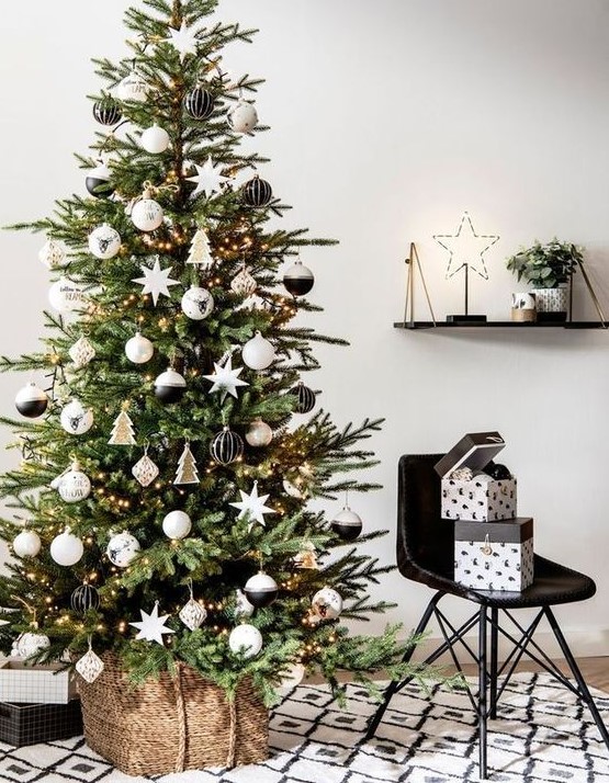 a beautiful modern Christmas tree with lights, black, white and stained plywood ornaments is a very chic idea suitable for a Nordic space