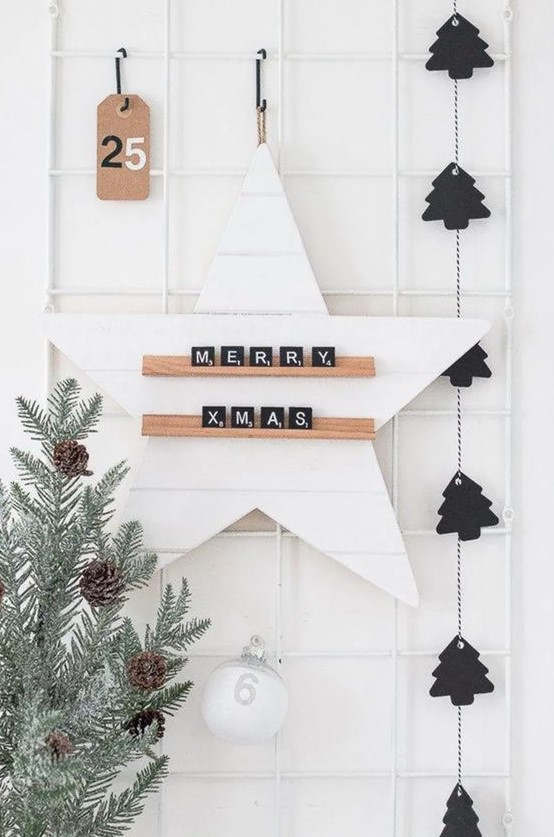 a black Christmas tree garland, a pale tree with pinecones and a star with scrabble letters