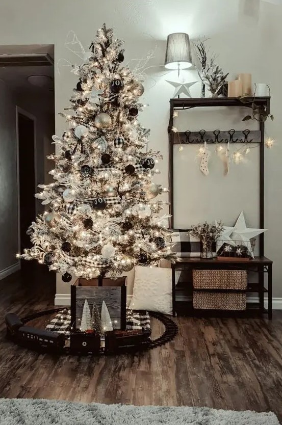 a farmhouse flocked Christmas tree with buffalo check ornaments and garlands, black and white ornaments and lights is a chic idea