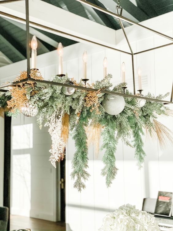 a frame chandelier with evergreens, dried blooms, mint and silver ornaments is a fresh and cool decoration for the holidays