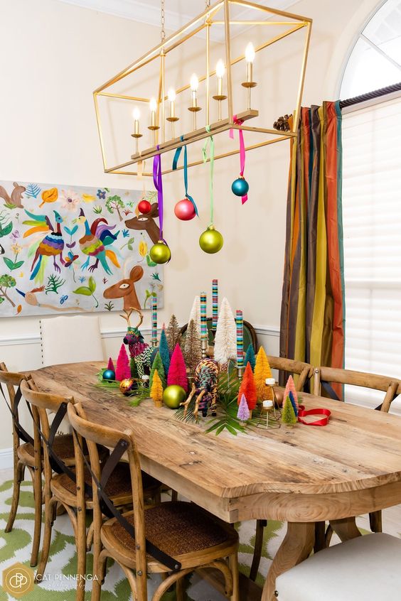 a gold frame chandelier decorated with colorful ornaments on colorful ribbon is a cool idea for the holidays