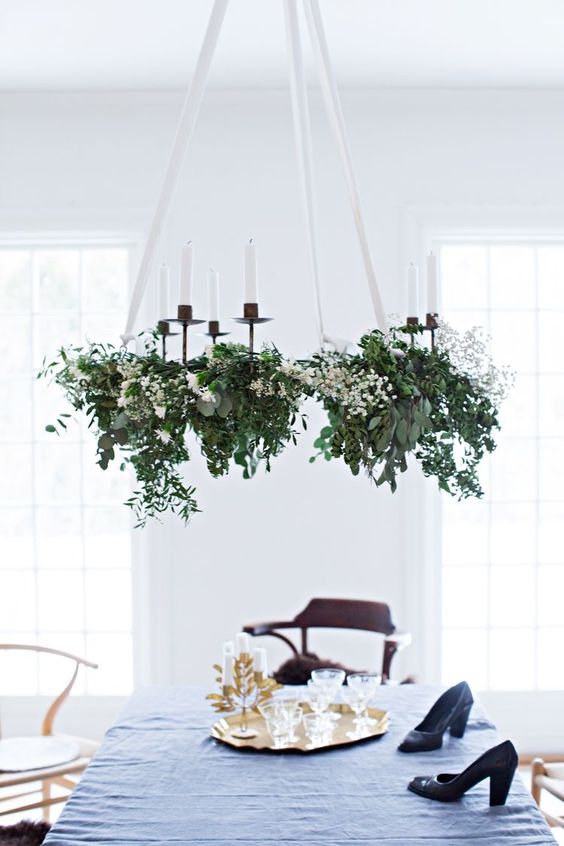 a lovely holiday chandelier of greenery, white blooms and candles is a stylish and catchy decoration for Christmas