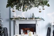 a modern holiday chandelier of eucalyptus, clear baubles with glitter inside is a stylsih modern Christmas decor idea