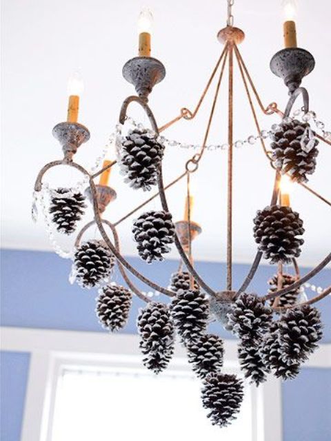 a shabby chic chandelier with crystals and snowy pinecones is a cool out of the box holiday decoration to rock