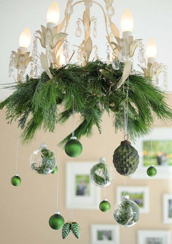 a stylish vintage floral chandelier with evergreens, green and clear ornaments with evergreens is wow