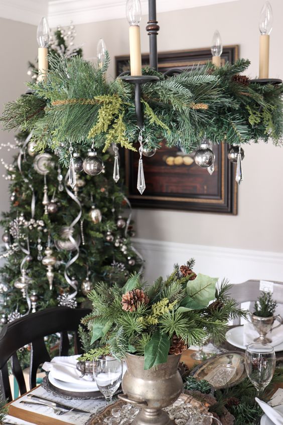 a vintage-inspired Christmas chandelier with evergreens, silver ornaments and crystals is a stylish and cool idea to rock