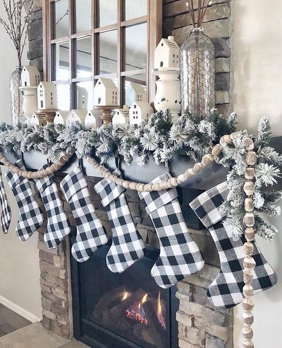 buffalo check stockings, flocked evergreens and wooden bead garlands for Christmas mantel decor