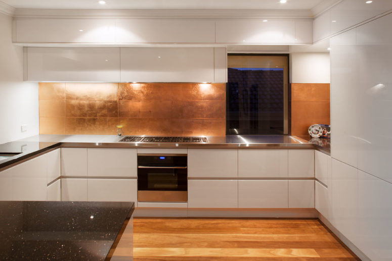 large copper tiles makes the backsplash looks masculine (Retreat Design)