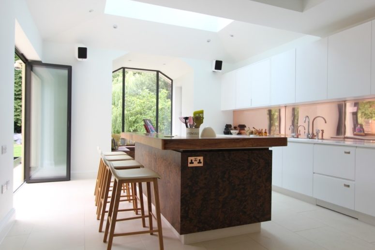 a glossy copper backsplash works well with pure white kitchen cabients