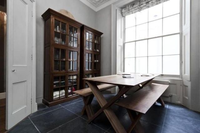 a large armoire and an indoor picnic style table on large slate floor