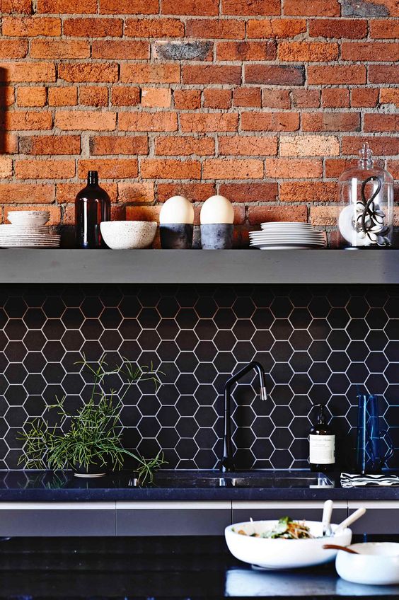 black hex tile backsplash with white grout and exposed red brick to make your kitchen stand out