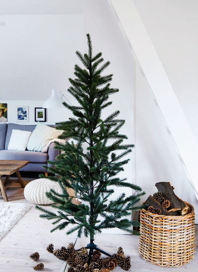 gorgeous christmas tree Christmas trees with no decor are a trend, and pinecones and firewood in the basket add a cozy touch