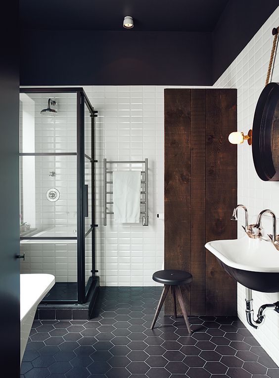 black hex tiles with white grout contrast with rectangle white tiles on the walls