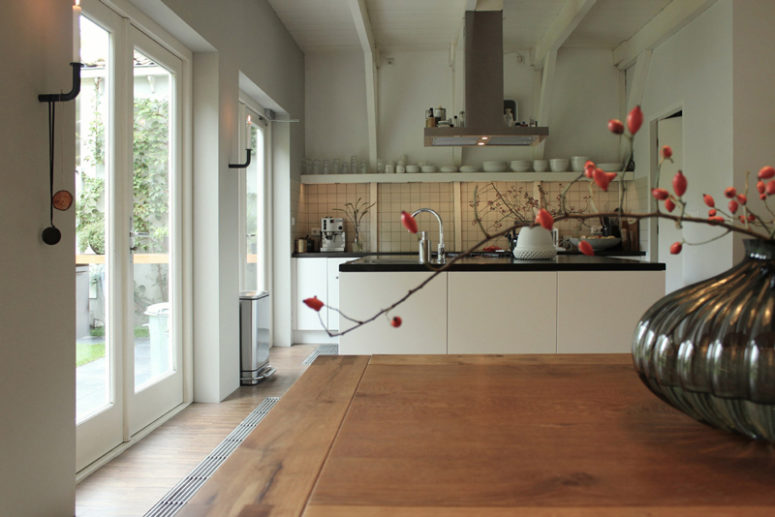 black and white kitchen The kitchen is a modern one, with black and white cabinets and open shelving for an airy look