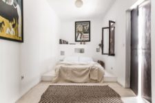 08 The bed in the master bedroom is placed onto a concrete platform, and an ethnic rug is a cool idea