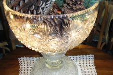 11 punch bowl filled with pinecones and lights
