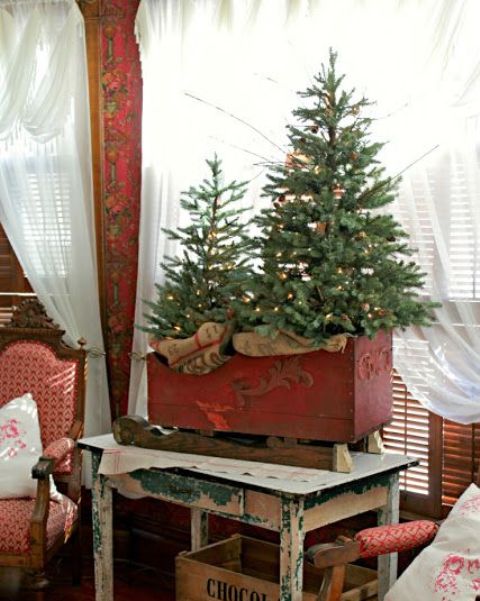 vintage red sleigh with a Christmas tree duo with lights