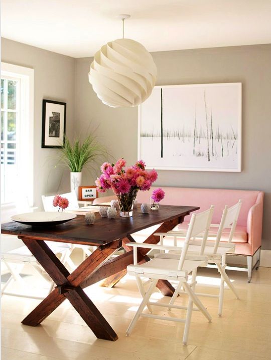 the contrast between a dark-stained picnic table, white chairs and a pink sofa is cool