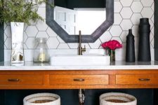 18 white hex tiles on the walls with black grout and a black framed mirror