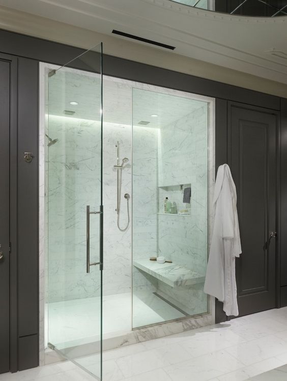 comfy marble steam room and shower with a bench and niches