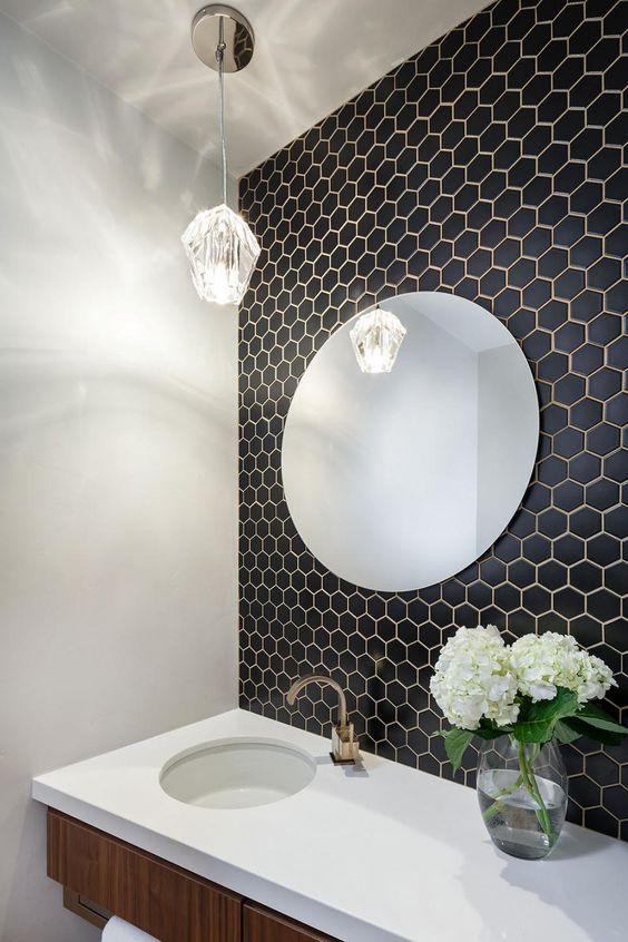 small black hex tiles on the bathroom wall with white grout