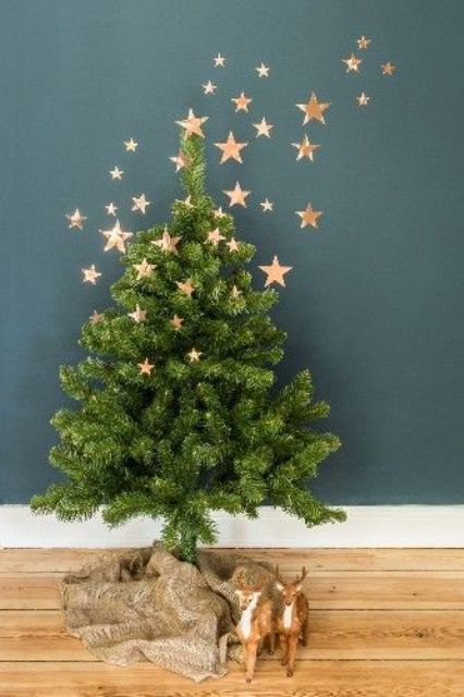 small tree with gold stars on it and on the wall